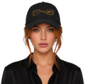 Woman wearing black INSPIRED Sovereign Dad Cap with gold embroidered logo front view