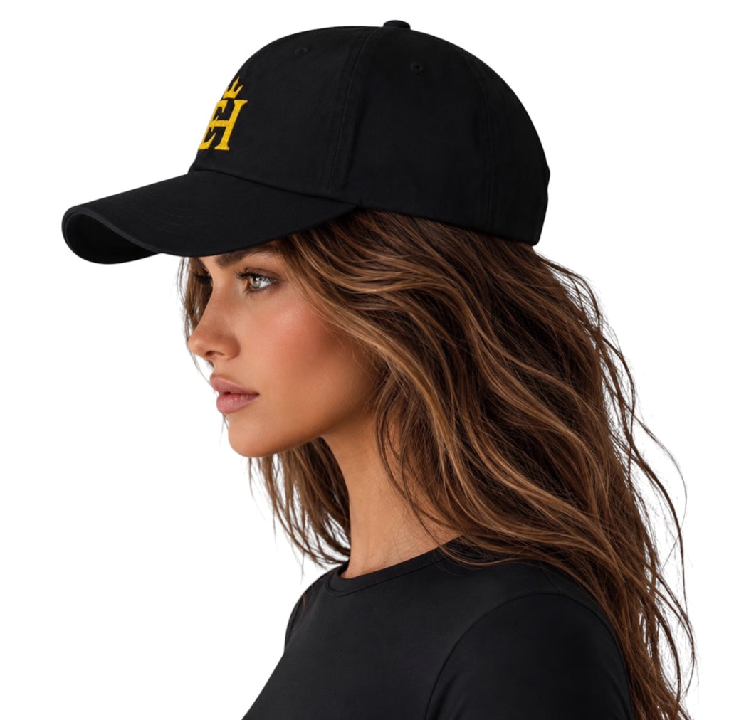 Woman wearing a black EH Crown Signature Classic Cap with gold embroidered EH Crown logo, side profile view.