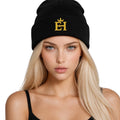 Woman wearing a black EH Crown Signature Cuffed Beanie with gold embroidered EH Crown logo, front view.