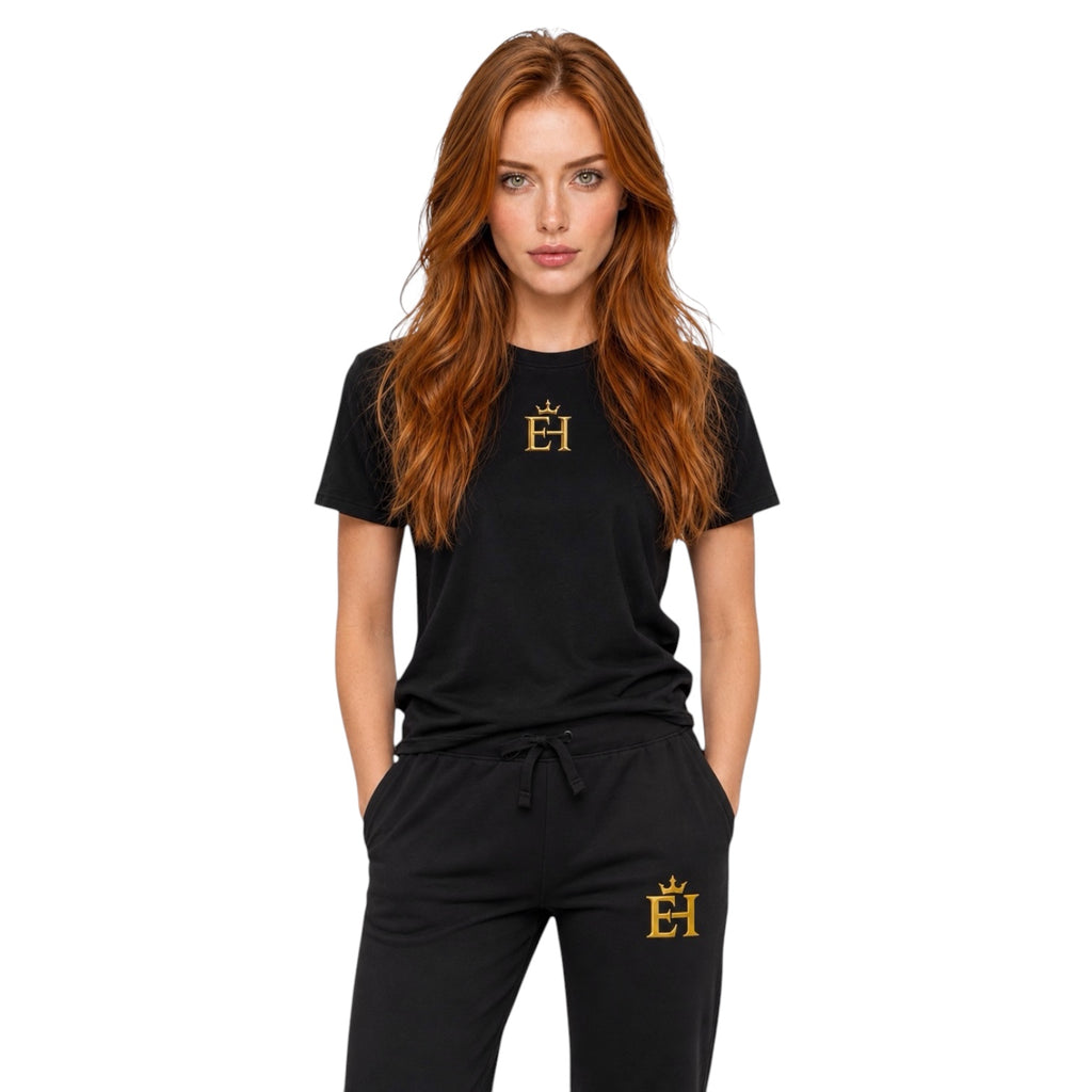 Full-body front view of a woman wearing the - black EH Crown Signature Heavyweight T-Shirt with gold EH Crown logo on a light neutral background.