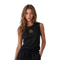 Woman wearing a black premium muscle tank with gold EH Crown embroidery in a front-facing hero pose.