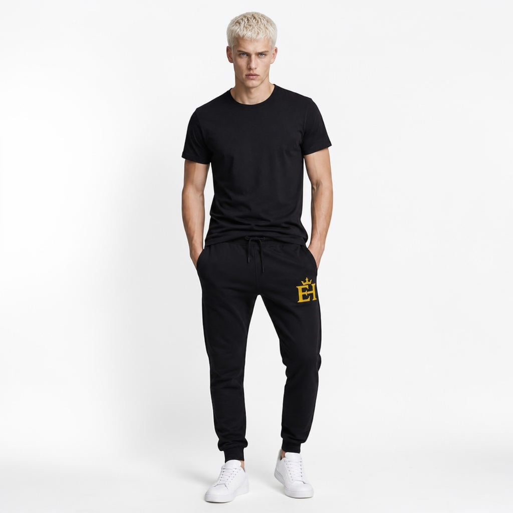 Man wearing black EH Crown Signature Premium Sweatpants with gold embroidery, front view.