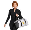 Woman carrying INSPIRED Duffle Bag in white with black straps and gold infinity-trident emblem