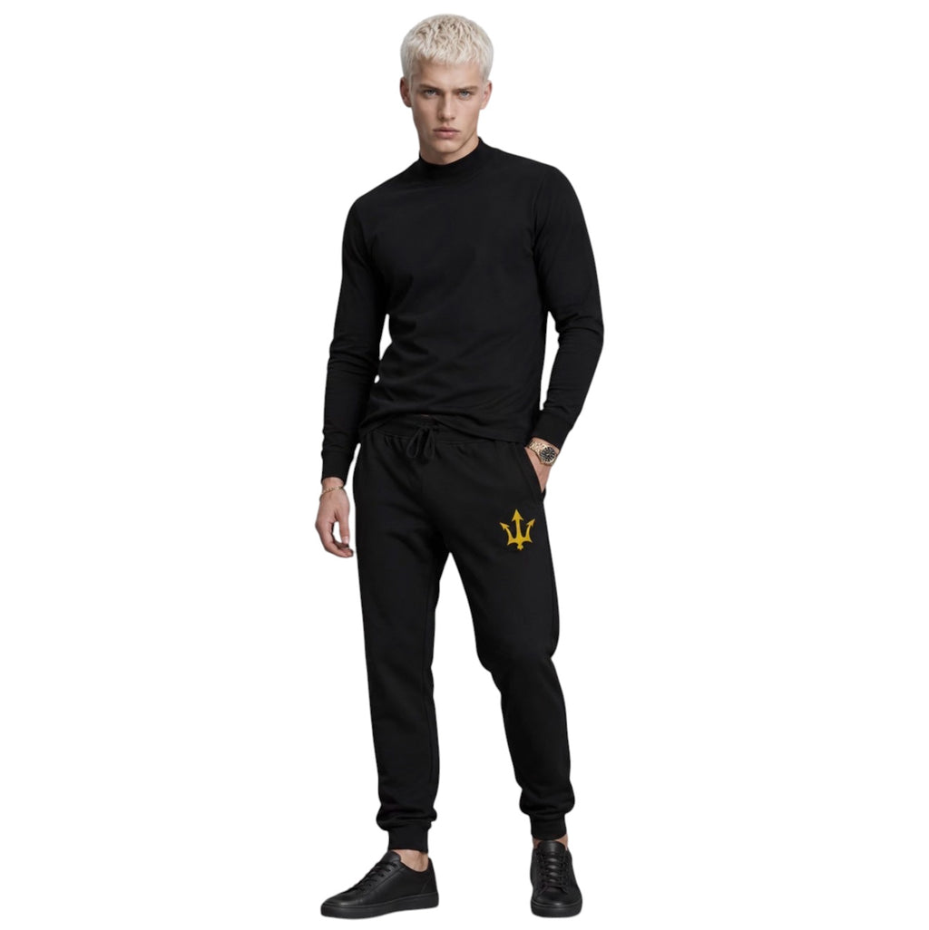 Male model wearing INSPIRED Sweatpants in black with gold infinity-trident emblem.